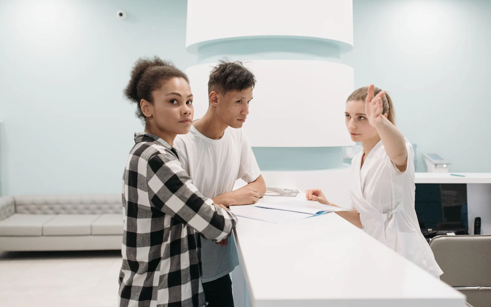 A neighborhood clinic reception team welcoming a visitor