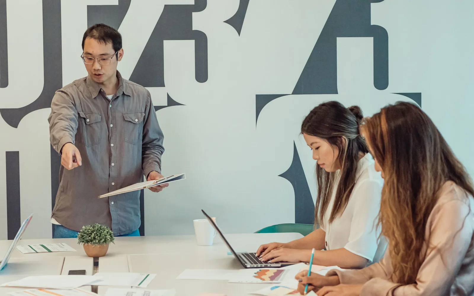 A team planning work together around a shared office table