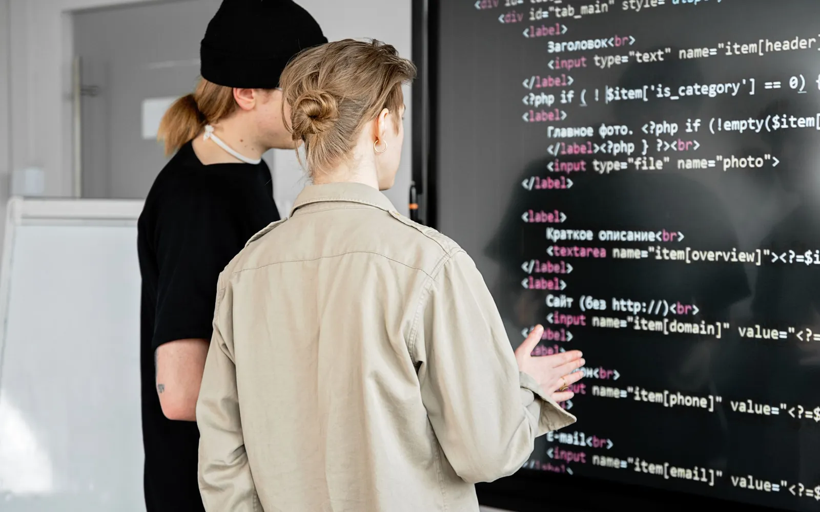 Developers reviewing application code on a large screen