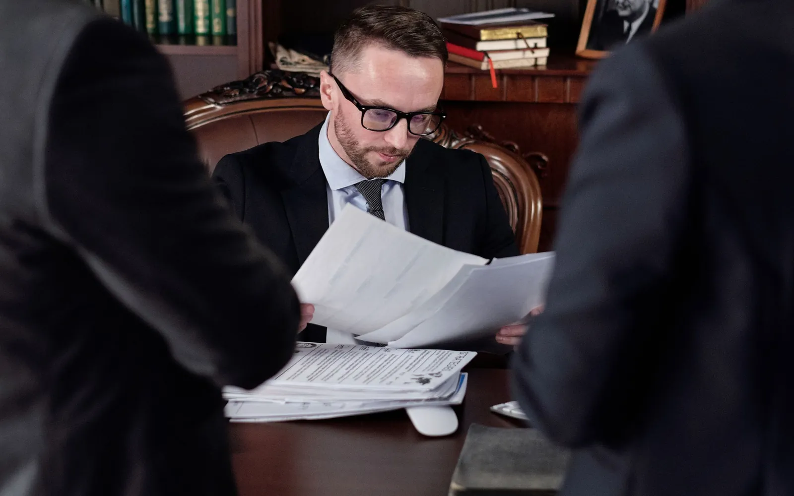 Professionals reviewing policy documents around an office table